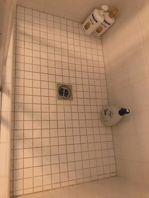 A tiled shower floor scrubbed clean by Warriors of the Order