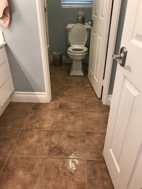 A sanitized bathroom with a spotless tile floor cleaned by Warriors of the Order
